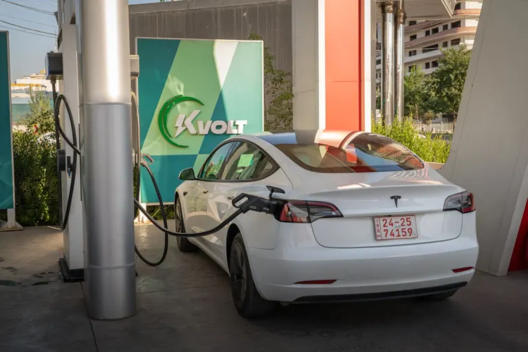 Carro elétrico conectado a um carregador rápido em estação pública, ilustrando a potência de recarga