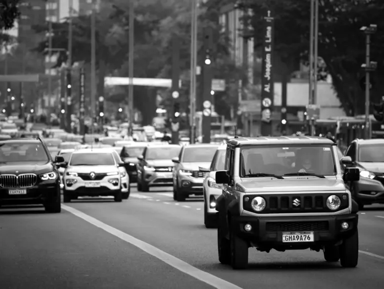 Carro elétrico circulando em avenida movimentada de São Paulo, ilustrando a isenção do rodízio municipal