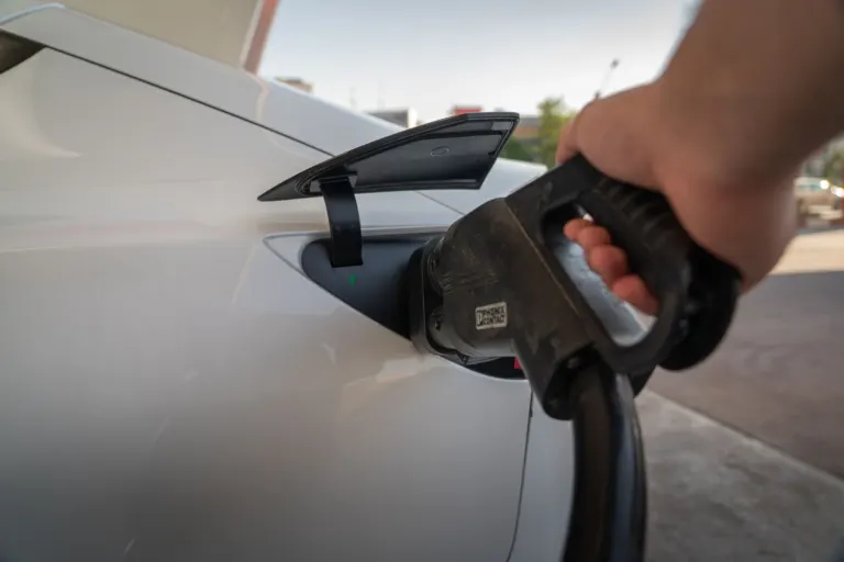Carro elétrico conectado a um carregador de parede na garagem de casa