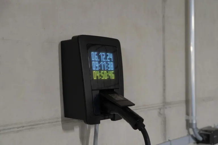 Carro elétrico conectado a carregador instalado em garagem residencial