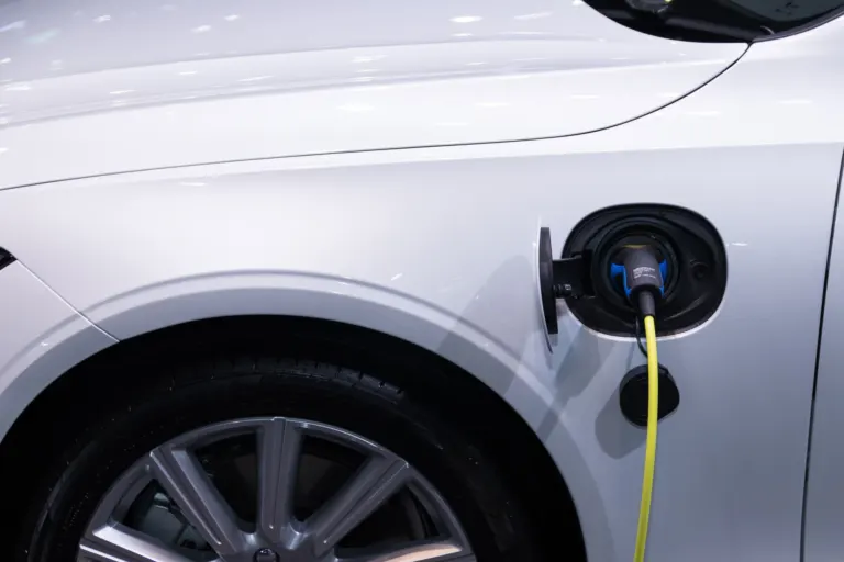 Carro híbrido plug-in conectado a um carregador residencial em uma garagem