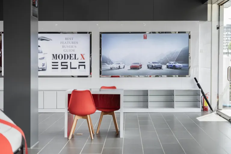 Carro elétrico novo em showroom de concessionária, ilustrando a compra de um elétrico com imposto de importação